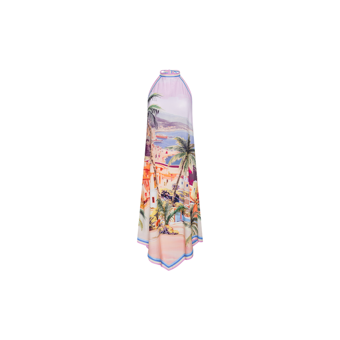 The Elise Cover-Up Dress is a sleeveless halter midi dress crafted from lightweight, water-safe crepe fabric, showcasing a scenic postcard print of a colorful seaside village with palm trees in vibrant shades of pink, purple, orange, and blue.