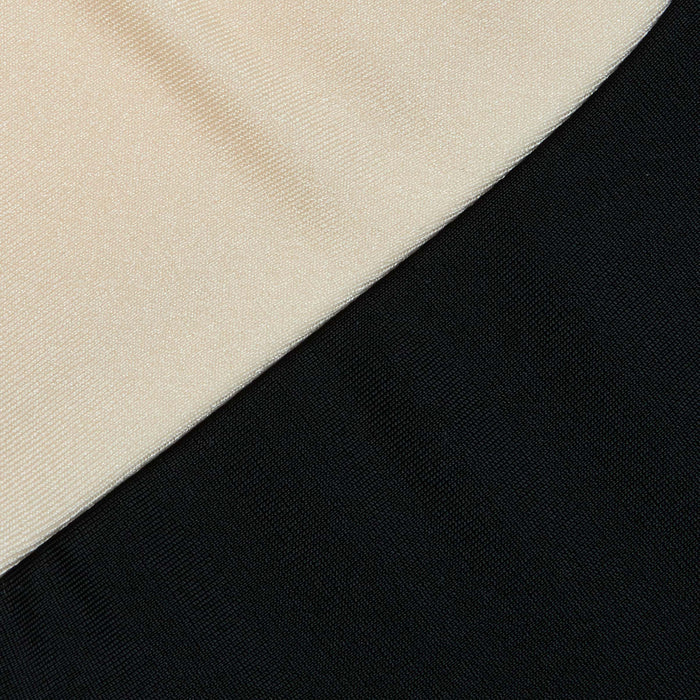 Close-up of the Emilia Bandeau One-Piece Swimsuit featuring two color-blocked fabric panels, one beige and one black, arranged diagonally with a distinct seam line separating the colors. The fabric textures are clearly visible.