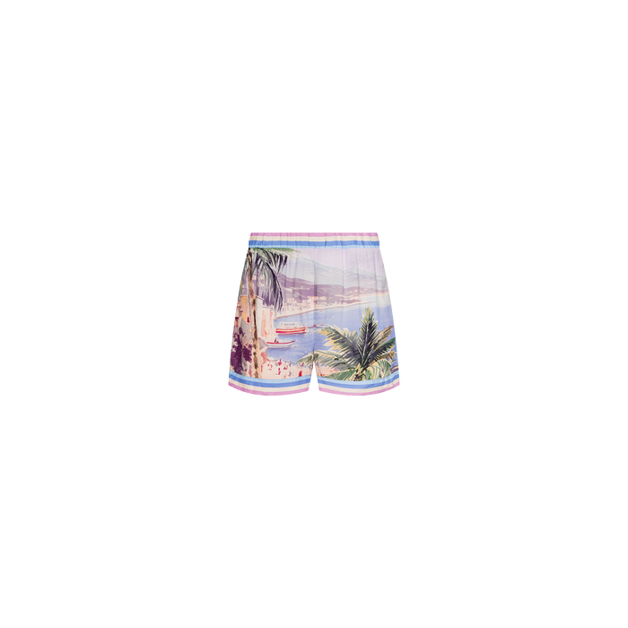 The Enyo Cover-Up Short showcases a scenic beach and palm tree postcard print with pastel accents, designed in a relaxed pull-on silhouette and displayed against a plain white background.