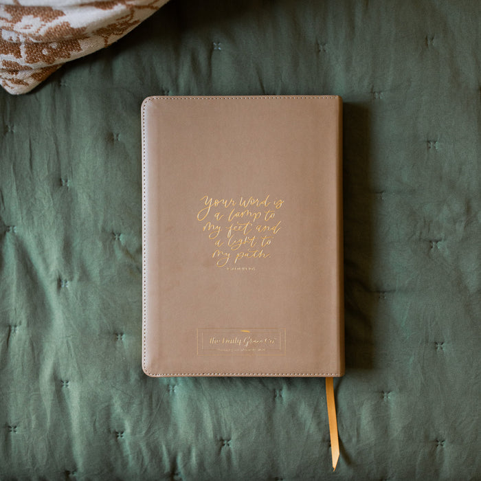 Back of a ESV Journaling Bible with gold etching on a green blanket