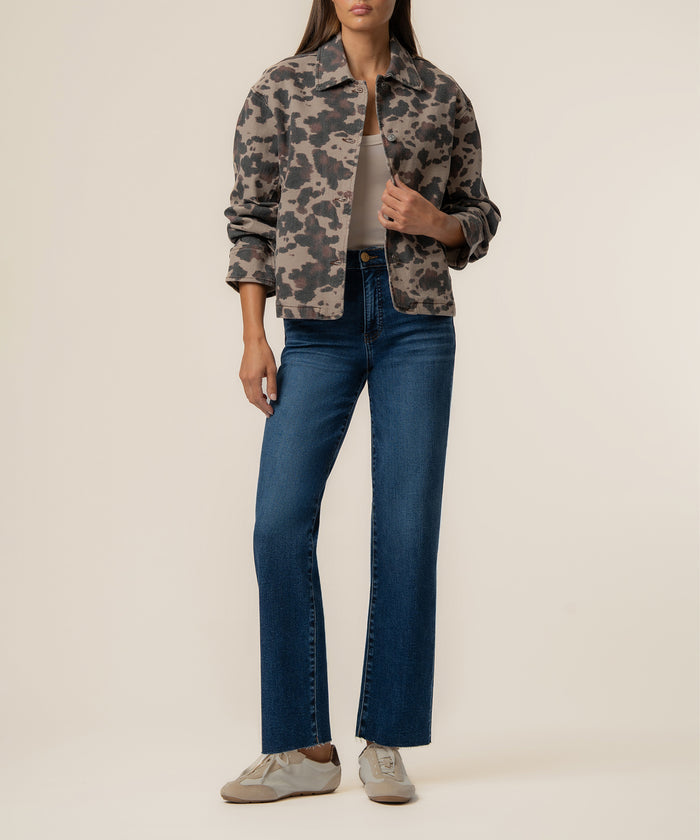 Taupe denim jacket with dark leopard print worn open over a white top and blue jeans.
