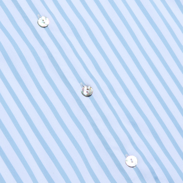Close-up of the Fawn Beach Print Shirt, featuring light blue and white vertical stripes crafted from organic cotton. The fabric is smooth, characteristic of a classic button-down dress shirt, with three white buttons sewn in a diagonal line.