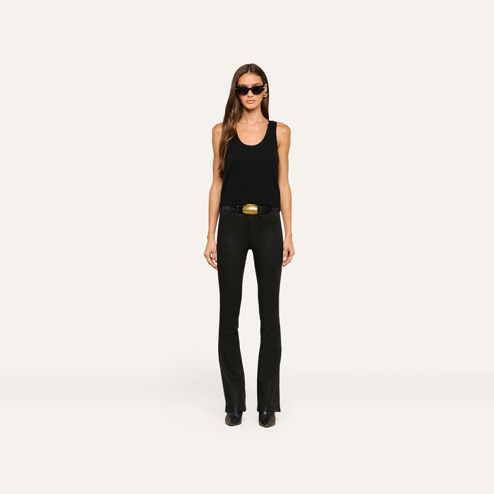 A woman wearing sunglasses, the Filou Cashmere Tank in black, black pants, a belt with a gold buckle, and black shoes stands facing forward against a plain white background.