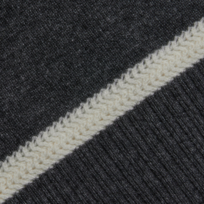 A close-up of the Filou Cashmere Tank in dark gray showcases a white textured stripe running diagonally across the fabric, featuring a delicate knitted pattern that highlights the refined texture characteristic of lightweight cashmere.