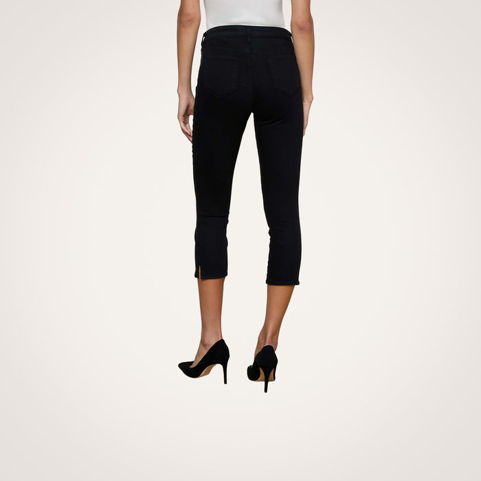A person is shown from the back, standing against a plain white background, wearing the Fiora Pedal Pusher Jean in black with super stretch denim and paired with black high heels.