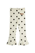 Off-white flared leggings with black polka dots and a small brown dachshund graphic on the upper right leg, shown flat against a light gray background.