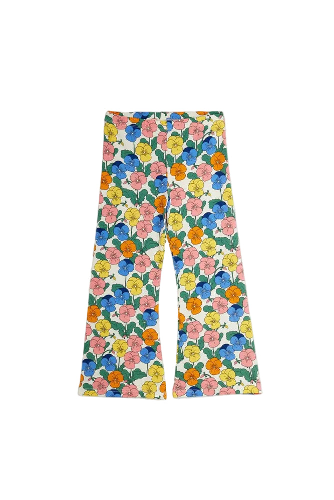 A pair of wide-leg pants featuring a colorful retro floral print with blue, pink, yellow, and orange flowers on a white background with green leaves.