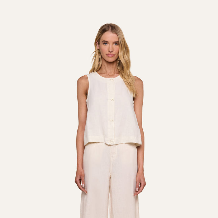 A woman stands facing forward against a plain light background, wearing the sleeveless Foster Linen Top with an A-line silhouette, paired with matching wide-leg pants.