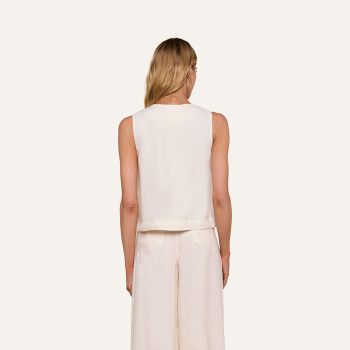 A woman with long blonde hair is shown from the back, wearing the sleeveless Foster Linen Top and matching wide-leg pants with an A-line silhouette against a plain light background.