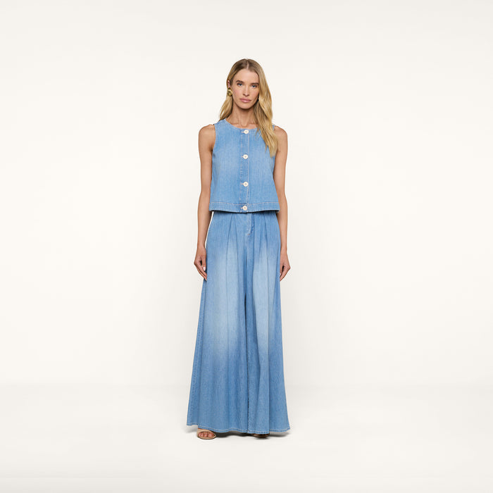 A woman stands against a plain white background, wearing the sleeveless Foster Top paired with matching wide-leg denim pants crafted from featherweight denim. She has long blonde hair and is looking straight at the camera.