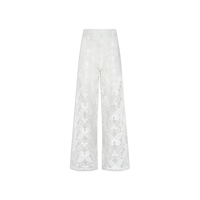 The Geraldine Cover-Up Pant is a white lace, high-waisted wide-leg pant showcasing a sheer floral pattern and subtle bohemian inspiration. Delicate and elegant, these pants are displayed against a plain white background.