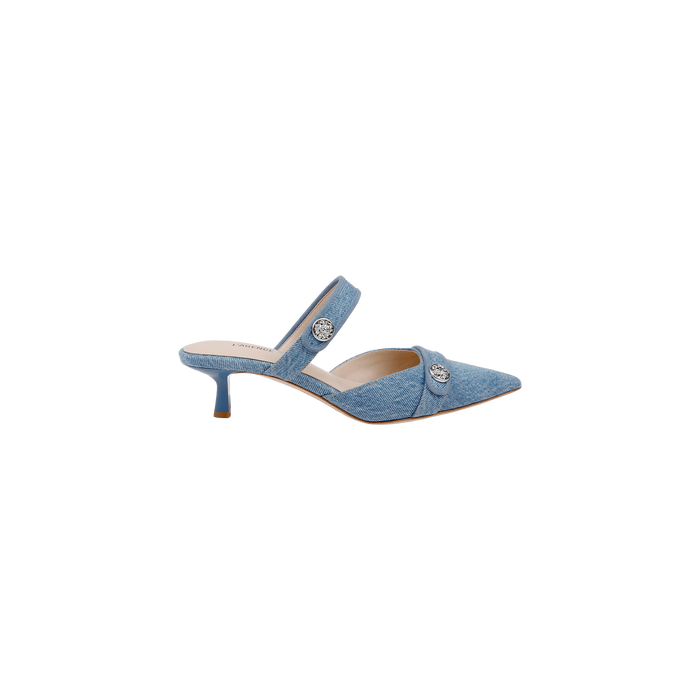 The Gilliane Denim Mule features a light blue denim design with a pointed toe, two straps adorned with decorative silver buttons, and a low kitten heel. Crafted for contemporary style, this modern mule also offers enhanced comfort with a memory foam insole. Pictured against a plain white background.