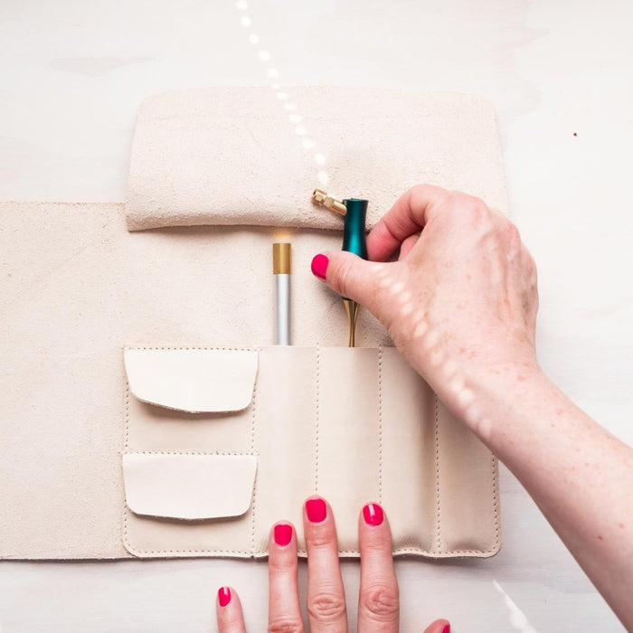 A calligrapher removing an oblique calligraphy pen from the Leather Pen Roll handmade by Edward de Lacy