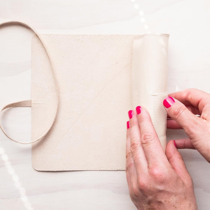 A person rolling the Leather Pen Roll handmade by Edward de Lacy