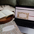 In Christ Alone Study next to an open laptop with the In christ alone study on it with a wooden tray next to the laptop with an open bible on it