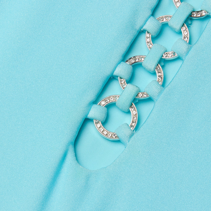 Close-up of the Indore One-Piece Swimsuit in ice blue, showcasing fabric with a cutout detail. Silver rings, linked by fabric loops, accentuate the design—some adorned with small, sparkling rhinestones.