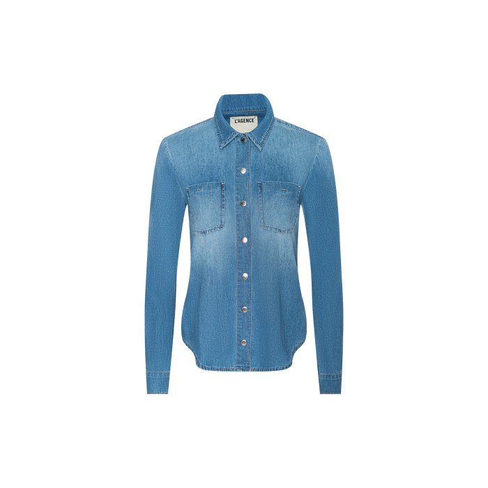 The Isla Shirt is a lightweight, long-sleeve denim shirt in a light blue vintage wash, featuring two chest pockets and a classic collar, shown against a plain white background.