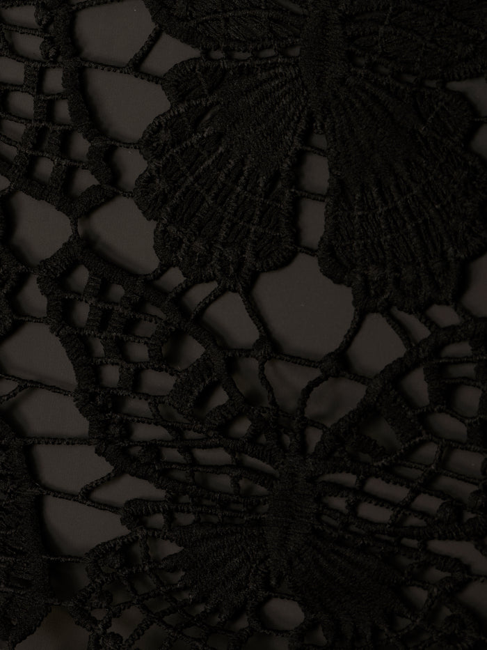 Close-up of the Janus Cover-Up Robe in black lace fabric, showcasing an intricate butterfly crochet pattern with delicate threads forming detailed wings and a finely textured appearance.