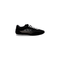 The Jarah Sneaker is a black suede shoe with white laces and a mesh side panel, displayed against a plain white background. This retro-inspired sneaker features a low profile, a white sole, and a comfortable memory foam insole.
