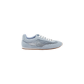 The Jarah Sneaker features a retro-inspired design in light blue suede, complemented by white laces, mesh side panels, suede accents, and a brown sole, displayed on a plain white background.