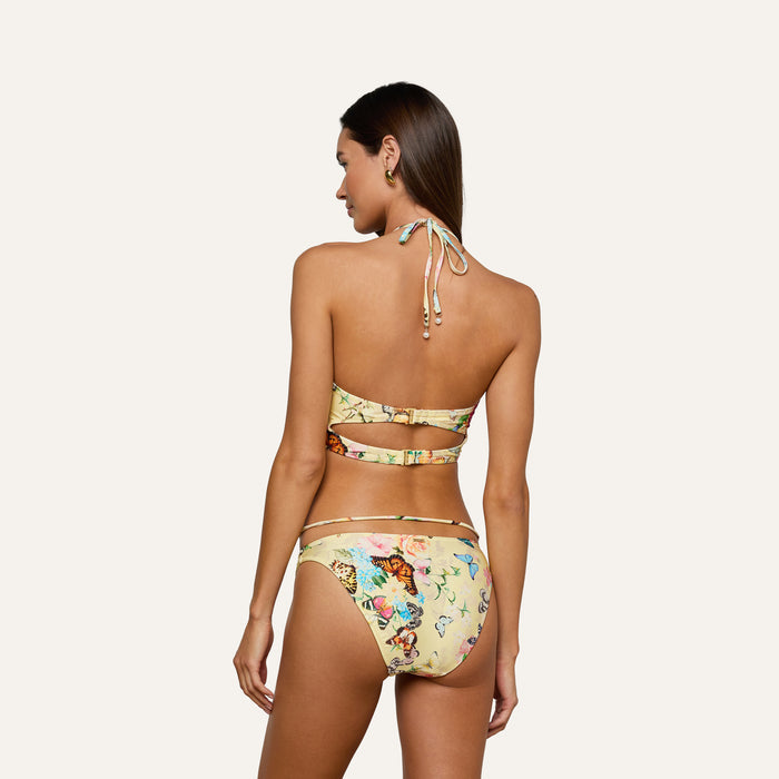 Woman with long brown hair modeling the Jean Bikini Bottom, featuring a butterfly print and high-leg cut, shown from the back against a plain light background.