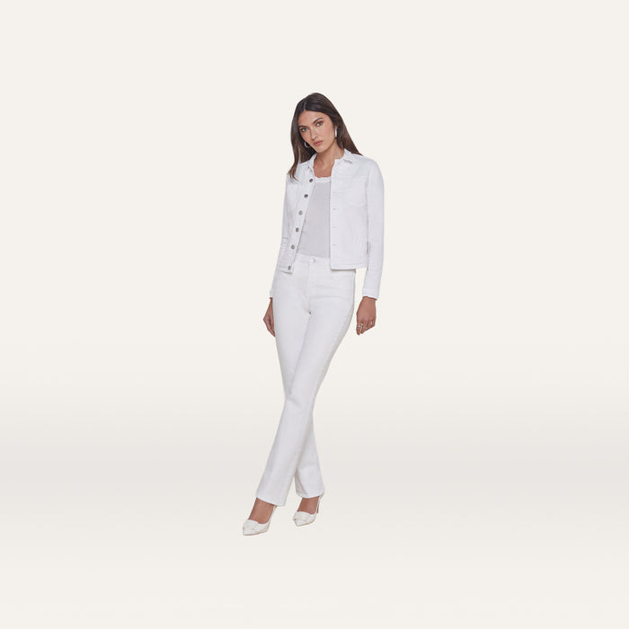 A woman stands facing forward, wearing the Celine Jean Jacket in optic white with a relaxed fit, paired with white pants, a light top, and white shoes against a plain white background.