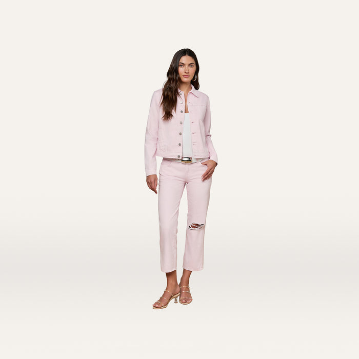 A woman stands against a white background wearing a pastel lilac Celine Jean Jacket in a slim fit, paired with matching pants featuring a rip at the knee and sandals.