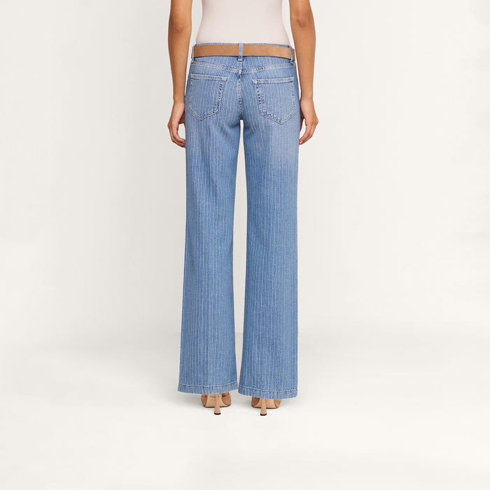 A person is shown from the back against a plain white background, wearing Joanne Low-Rise Wide-Leg Jeans and beige heels.