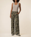 Olive patterned high-rise wide-leg jeans with straight silhouette, paired with beige sleeveless tank top.
