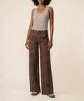 Woman wearing high-rise wide-leg jeans in terrain snake print with a sleeveless gray tank top.