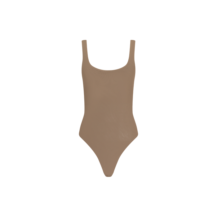 The Kalea Mesh Bodysuit is a taupe, sleeveless lightweight piece featuring a scoop neckline and high-cut legs, shown against a plain white background.