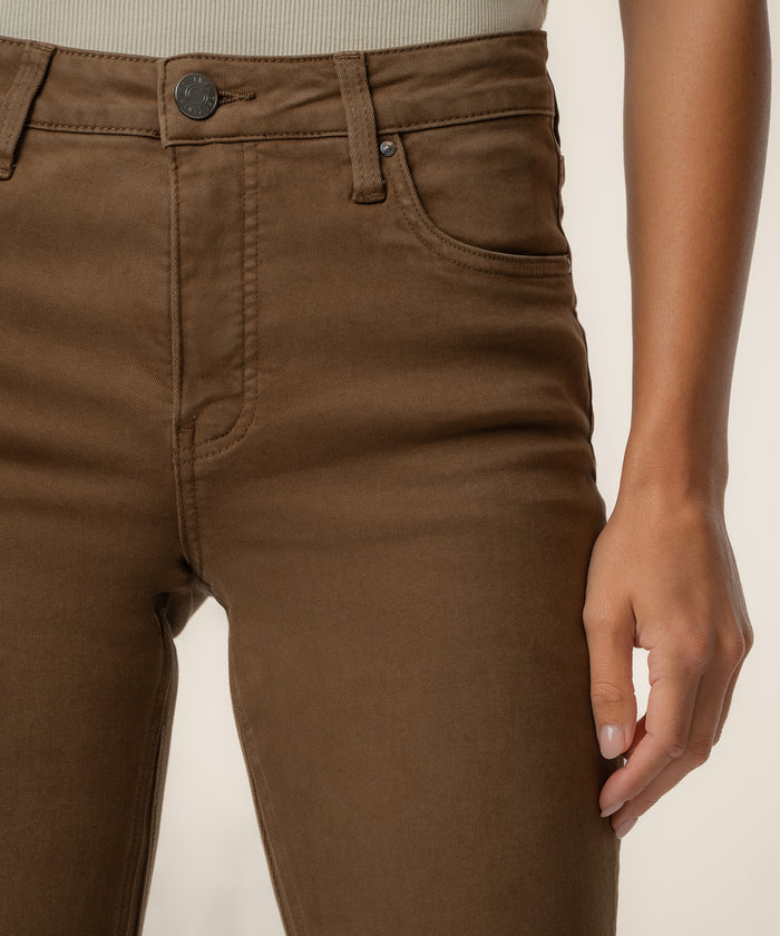 Pecan-colored high-rise ankle flare jeans with button closure and front pockets, shown on model at waist level.