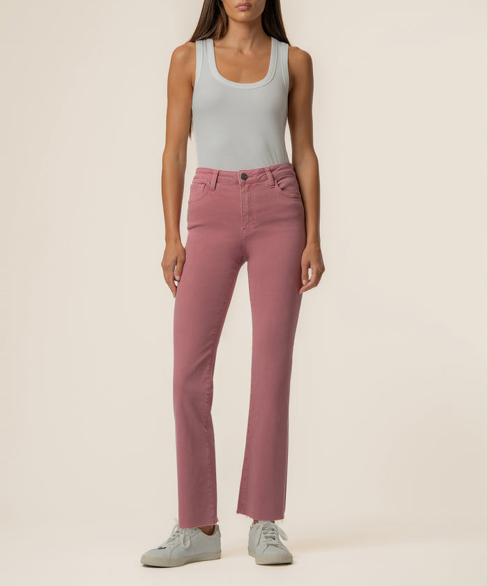 Woman wearing rose pink high-rise ankle flare jeans with a gray sleeveless tank top.