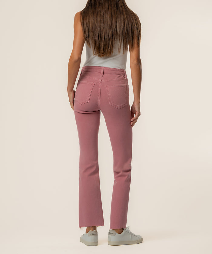 Rose pink high-rise ankle flare jeans with frayed hem, shown from back view on model wearing white tank top.