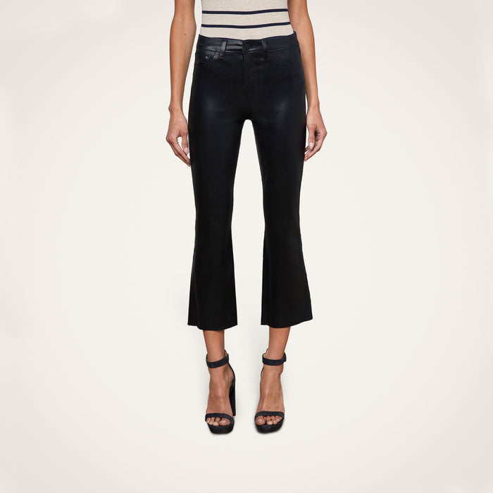 A person wearing the Kendra Coated Cropped Flare Jean, a sleeveless striped top, and black high-heeled sandals stands against a plain light background.
