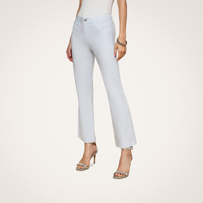 A woman is shown standing against a plain white background wearing the Kendra Coated Cropped Flare Jean. The high-rise, light-colored jeans feature a flared cropped silhouette. She pairs them with high-heeled sandals, and her upper body is partially out of frame.