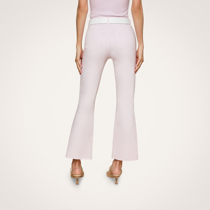 Model wearing the Kendra Coated Cropped Flare Jean in light pink, styled with a matching belt and heeled sandals, shown from the back against a plain white background.