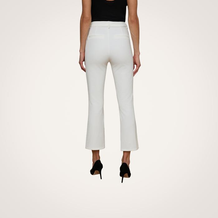 A woman is shown from the back against a plain light background, wearing the Ketra Bootcut Trouser in white stretch suit fabric, paired with black heels.