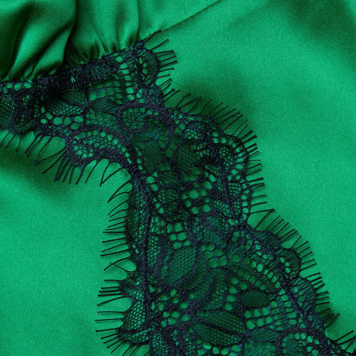 Close-up of the Kimber Silk Lace Camisole, showcasing green satin fabric with a black lace trim adorned with a floral pattern and delicate fringe.
