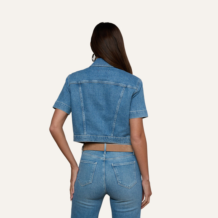 A woman with long brown hair is shown from the back, wearing the Kirstie Jean Shirt Jacket and high-waisted blue jeans against a plain light background.