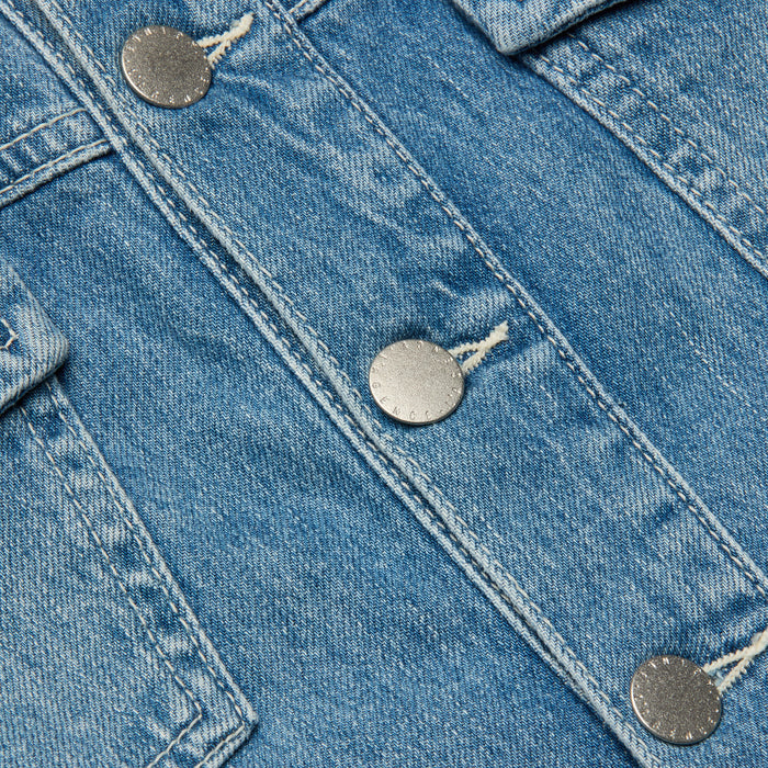 Close-up of blue denim fabric with metallic buttons and visible stitching, highlighting a section of the Kirstie Jean Shirt Jacket.