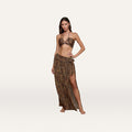 A woman poses barefoot against a plain white background, wearing a leopard print bikini top and the Klaire Cover-Up Skirt—a matching wrap skirt with a high slit crafted from lightweight viscose chiffon for an effortless look.
