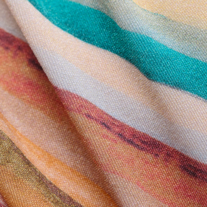 Close-up of the Krysta Halter Bikini Top fabric, featuring wavy, horizontal stripes in teal, orange, yellow, brown, and cream hues. The slightly folded material highlights its textured surface and retro-inspired pattern.