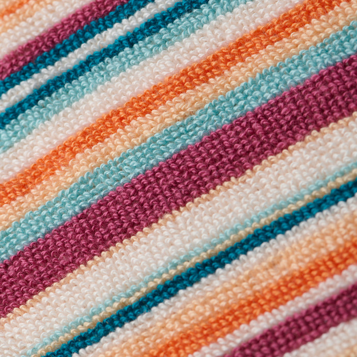Close-up of the Lee Cover-Up Poncho, showcasing colorful, textured fabric with diagonal stripes in shades of purple, orange, teal, and white. The woven material evokes the soft and cozy feel of terrycloth—ideal for poolside lounging or relaxing after a swim.