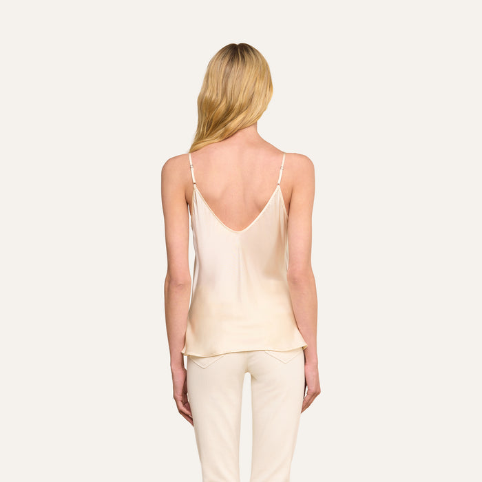 A woman with long blonde hair models the Lexi Silk Camisole in pearl white, paired with matching pants, shown from the back against a plain light background.