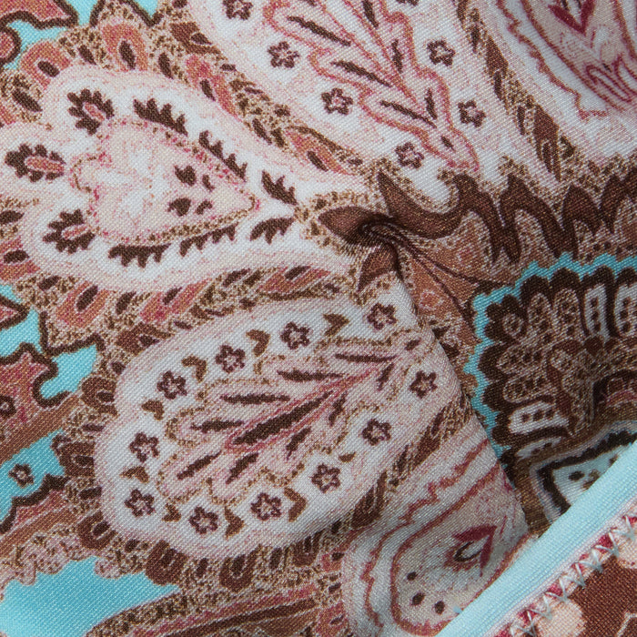 Close-up of the Lexie Bikini Top, featuring colorful fabric with an intricate paisley print in shades of pink, brown, and blue. The detailed stitching and decorative designs are highlighted, along with its adjustable straps.