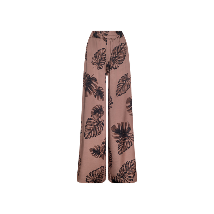 Lillian Satin Pant: Ultra-wide, high-waisted satin trousers in light brown with a black palm leaf print, displayed against a plain white background.