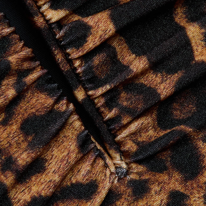 Close-up of gathered fabric from the Lilou One-Piece Swimsuit, showcasing its leopard print with brown and black spots and visible stitching down the center.