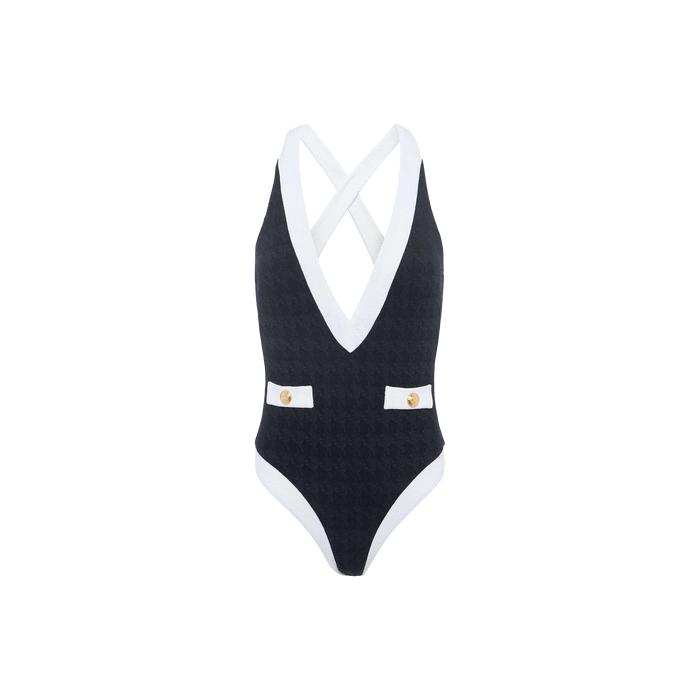 The Lisa Plunge One-Piece Swimsuit features a black textured bouclé fabric, a deep V-neckline with white trim, criss-cross back straps, and two decorative buttons at the waist. Designed for moderate bottom coverage, this swimsuit blends modern elegance with a flattering silhouette.