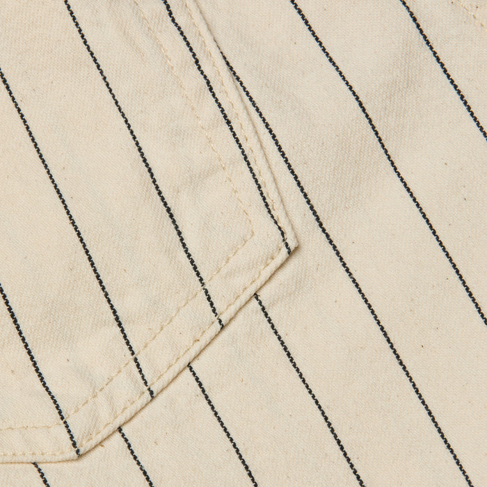 Close-up of the Lissania Short in beige, featuring thin vertical black pinstripes and visible stitching around the edge of a pocket.